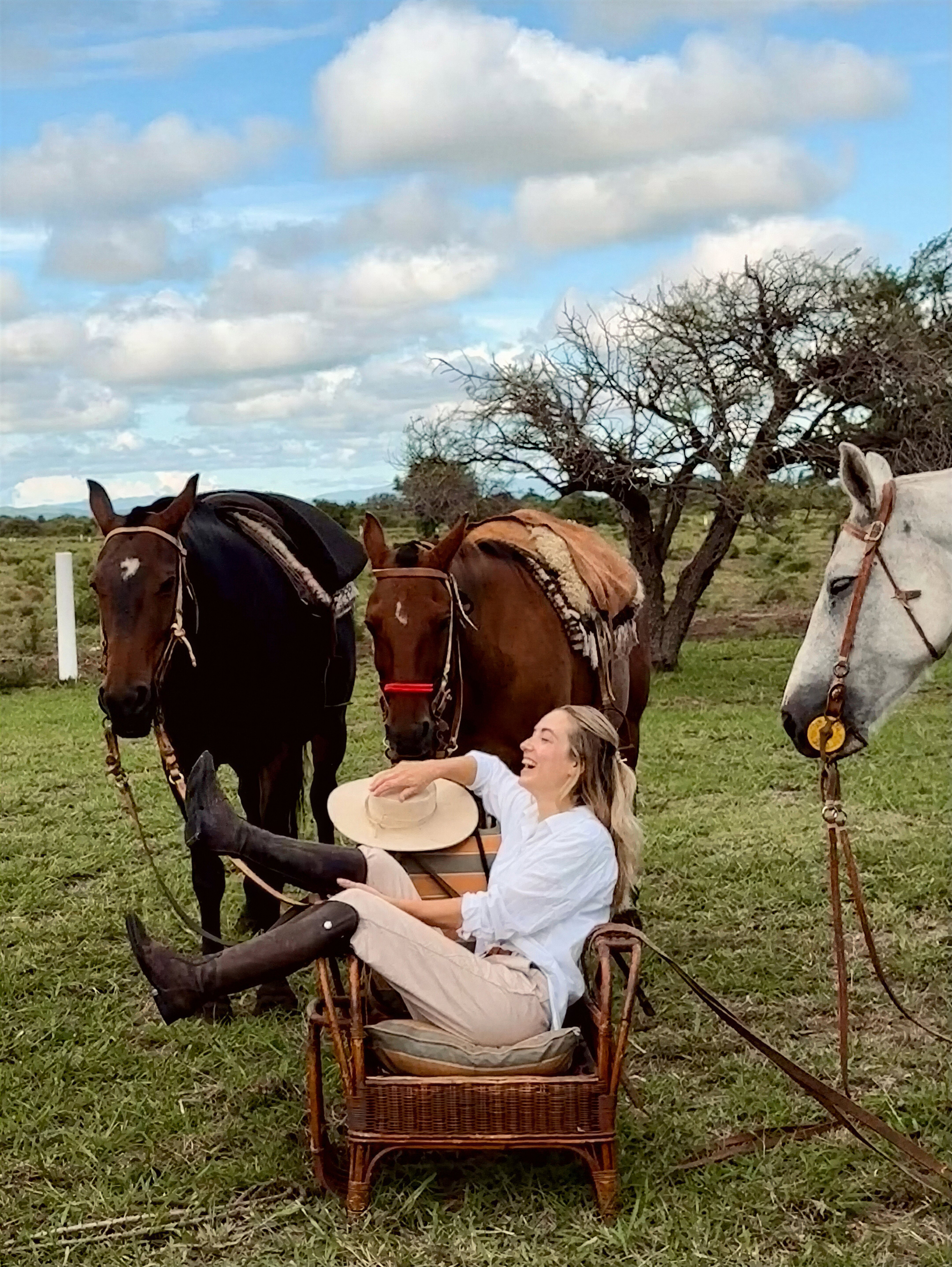 Relaxing in a wicker chair surrounded by horses